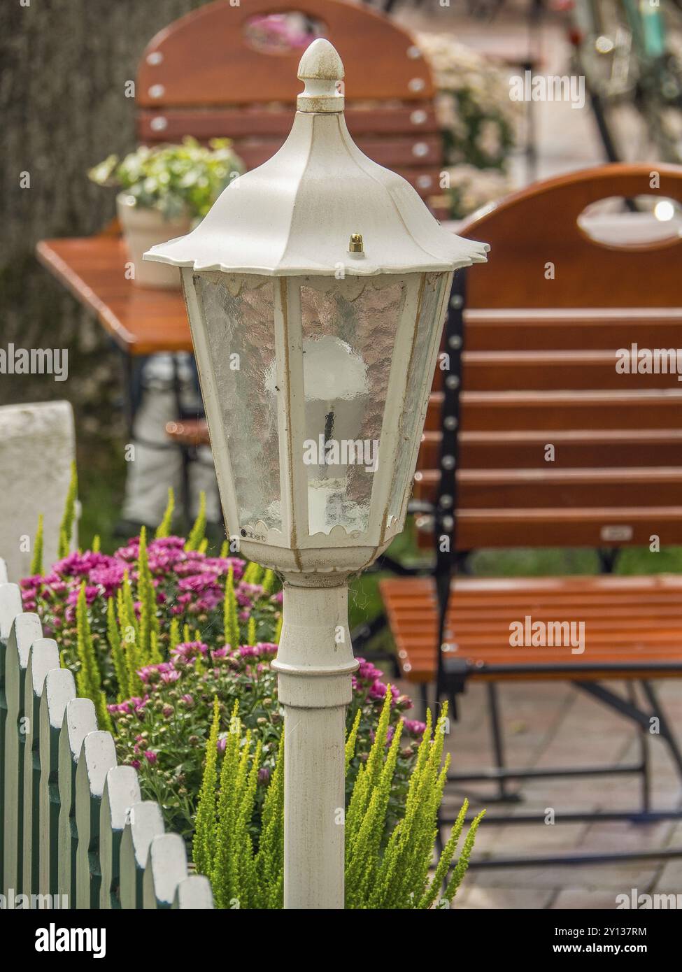 Lanterne blanche dans l'espace extérieur d'un restaurant avec tables et chaises en bois, spiekeroog, frise orientale, mer du Nord, allemagne Banque D'Images