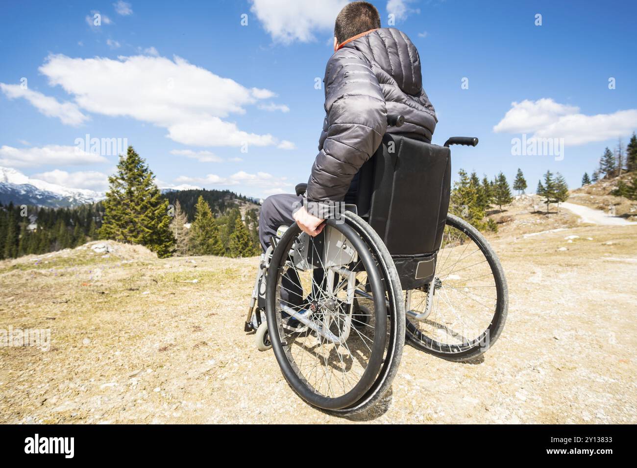 Jeune homme handicapé en fauteuil roulant à l'extérieur dans la nature l'observation de montagne et la nature Banque D'Images