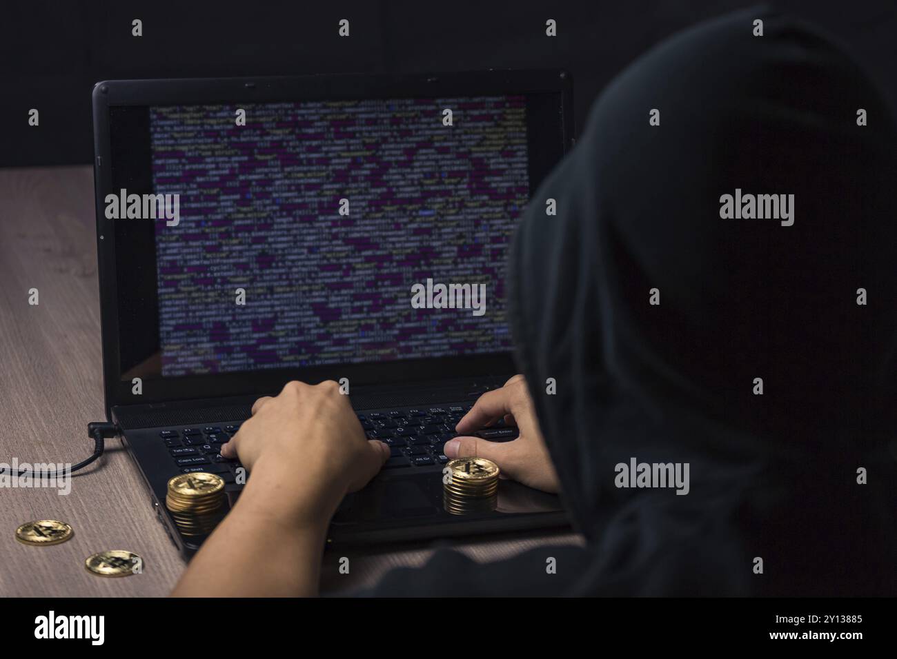 Hacker à capuchon dangereux sur l'ordinateur portable se casse la sécurité informatique sistem et voler des cryptocurrency bitcoin Banque D'Images