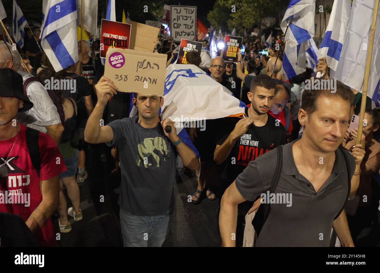 JÉRUSALEM - 2 SEPTEMBRE : les manifestants portent des cercueils enveloppés de drapeaux israéliens en signe de solidarité avec les six personnes enlevées assassinées ce week-end en captivité par le Hamas, lors d'une manifestation près de la maison privée du premier ministre Benjamin Netanyahu, appelant le gouvernement israélien à négocier un accord de libération des otages avec le Hamas le 2 septembre 2024 à Jérusalem. Israël Banque D'Images