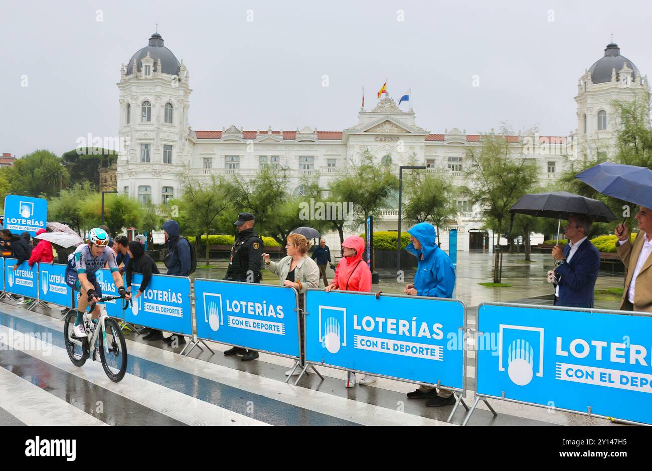 Cycliste en compétition dans la 17ème étape de la Vuelta de Espana sous une pluie battante Plaza de Italia Santander Cantabrie Espagne Europe 4 septembre 2024 Banque D'Images