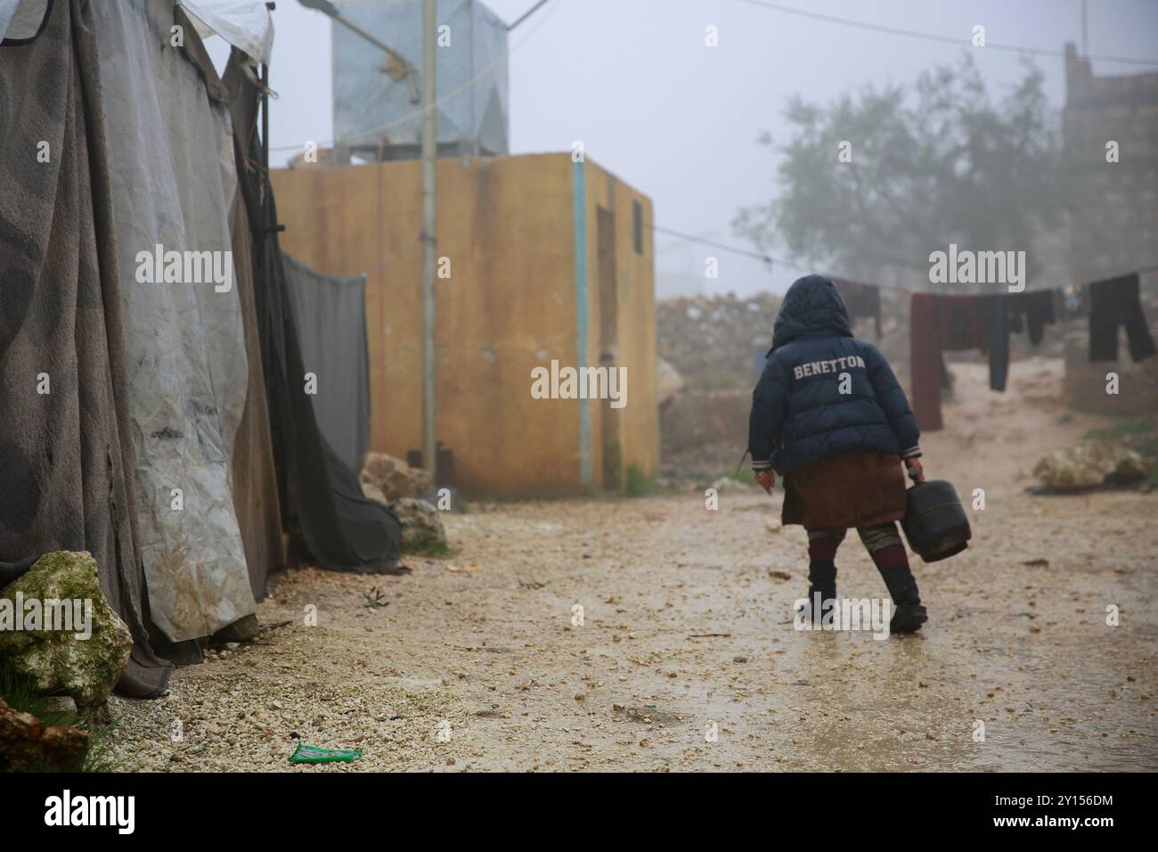 Harem, Idlib, Syrie.16 janvier 2024. Des Syriens déplacés au milieu des conditions hivernales humides et boueuses dans les camps de déplacés informels de la campagne du Harem, dans le gouvernorat d’Idlib, dans le nord-ouest de la Syrie. Alors que les pluies hivernales s’installent, les habitants des camps mal équipés du gouvernorat d’Idlib continuent de lutter contre la pauvreté, le conflit de faible intensité, le froid, la boue et l’eau qui s’infiltre à travers les tentes Banque D'Images