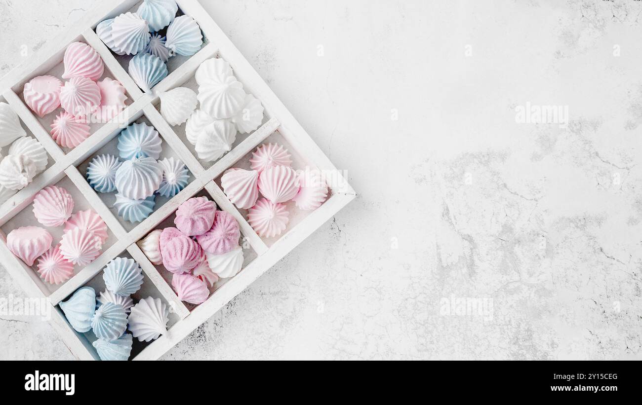 boîte de petite meringue artisanale colorée sur la table. fleurs de meringue faites à la main préparées pour offrir en cadeau. Doux cadeau romantique. Vue de dessus, copier s Banque D'Images