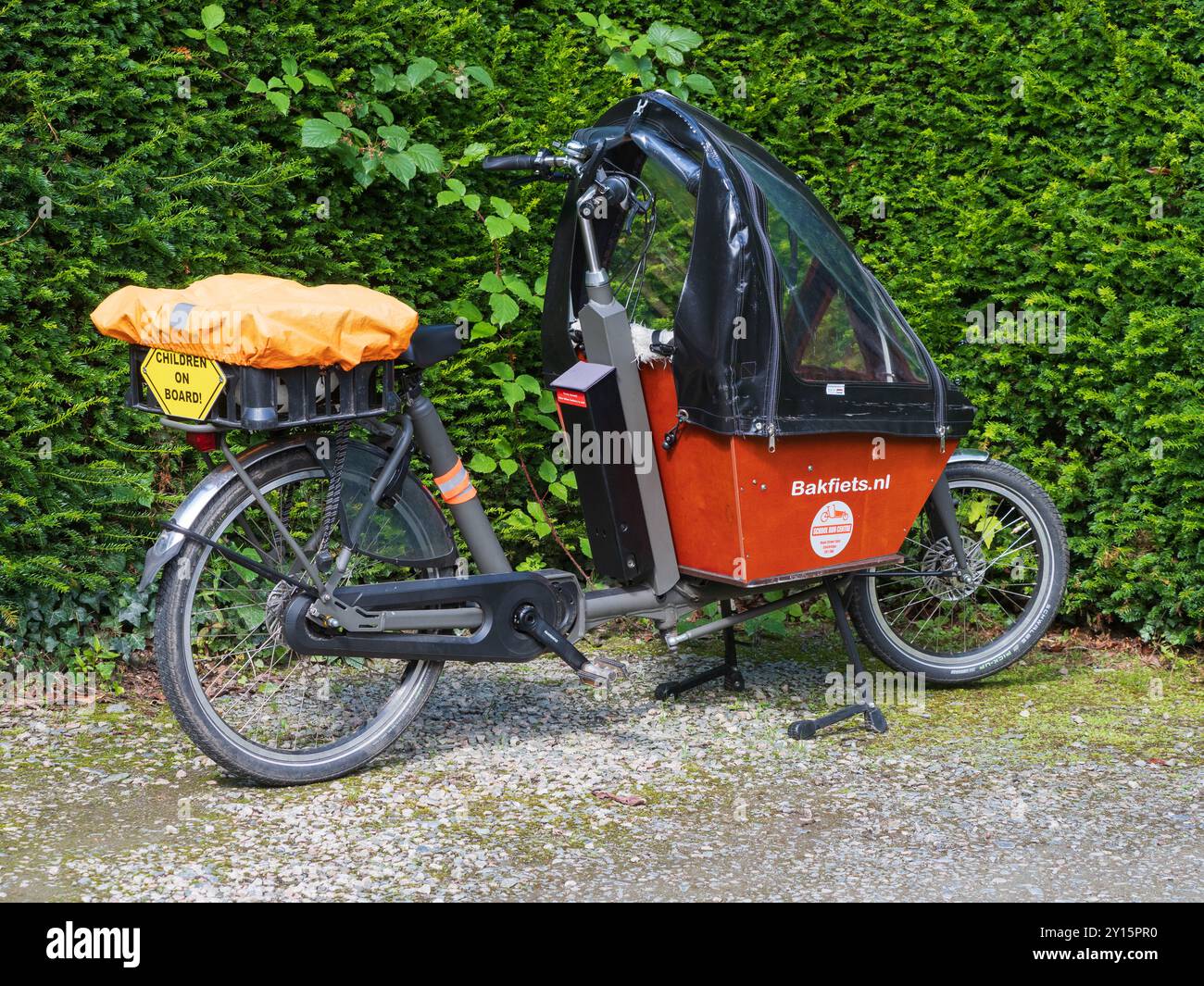 Vélo cargo électrique Bakfiets de construction néerlandaise configuré pour transporter des enfants dans le porte-bagages avant couvert Banque D'Images