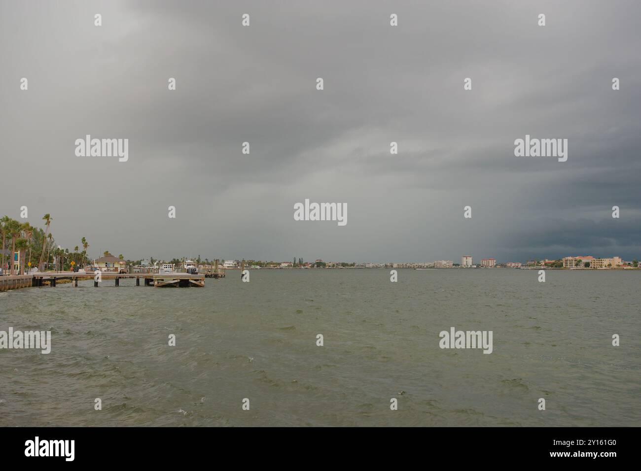 Large vue sur Bay Water vers l'île de Vina Del Mar par une journée nuageuse tard dans l'après-midi. Quai de bateau de jetée et bateaux sur la gauche. Nuages orageux sombres Banque D'Images