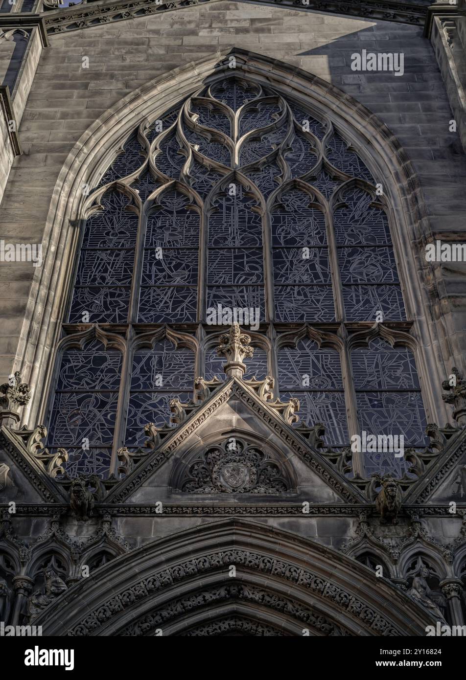 Édimbourg, Écosse - 18 janvier 2024 - le soleil brille à travers la surface des vitraux arqués et le pignon se trouve au-dessus de la porte d'entrée de St. Banque D'Images