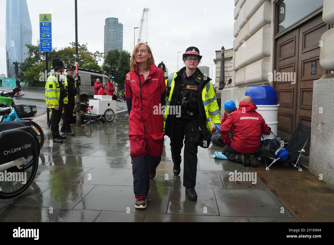 La police retire les militants devant le siège d'Unilever dans le centre de Londres, Greenpeace UK ayant bloqué l'accès au bâtiment, affirmant que la société de biens de consommation « saccage la planète et nuit aux communautés » à travers des plastiques à usage unique. Les membres du groupe de campagne pour l'environnement se sont bloqués sur des barricades fabriquées à partir de produits géants Dove, l'une des plus grandes marques d'Unilever, le logo de chaque produit étant changé en Dove morte. Date de la photo : jeudi 5 septembre 2024. Banque D'Images