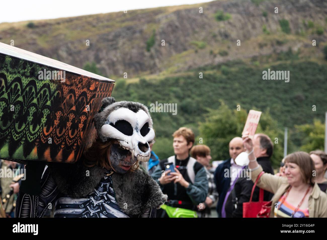 Surge Scotland interprétant un extrait funèbre de son spectacle de rue à grande échelle et de son spectacle musical de pandémonium "Beautiful Bones", dans le cadre d'une manifestation devant le Parlement écossais le 5 septembre 2024 en réponse à Creative Scotland annonçant sa décision le 19 août de supprimer son fonds pour les professionnels des arts individuels en raison de contraintes financières du gouvernement écossais; une annonce a été faite tard le 4 septembre que le fonds serait rétabli, mais il y a des inquiétudes concernant l'avenir du financement des arts en Écosse. Cette manifestation était organisée par STUC (Scottish Trades Unio Banque D'Images