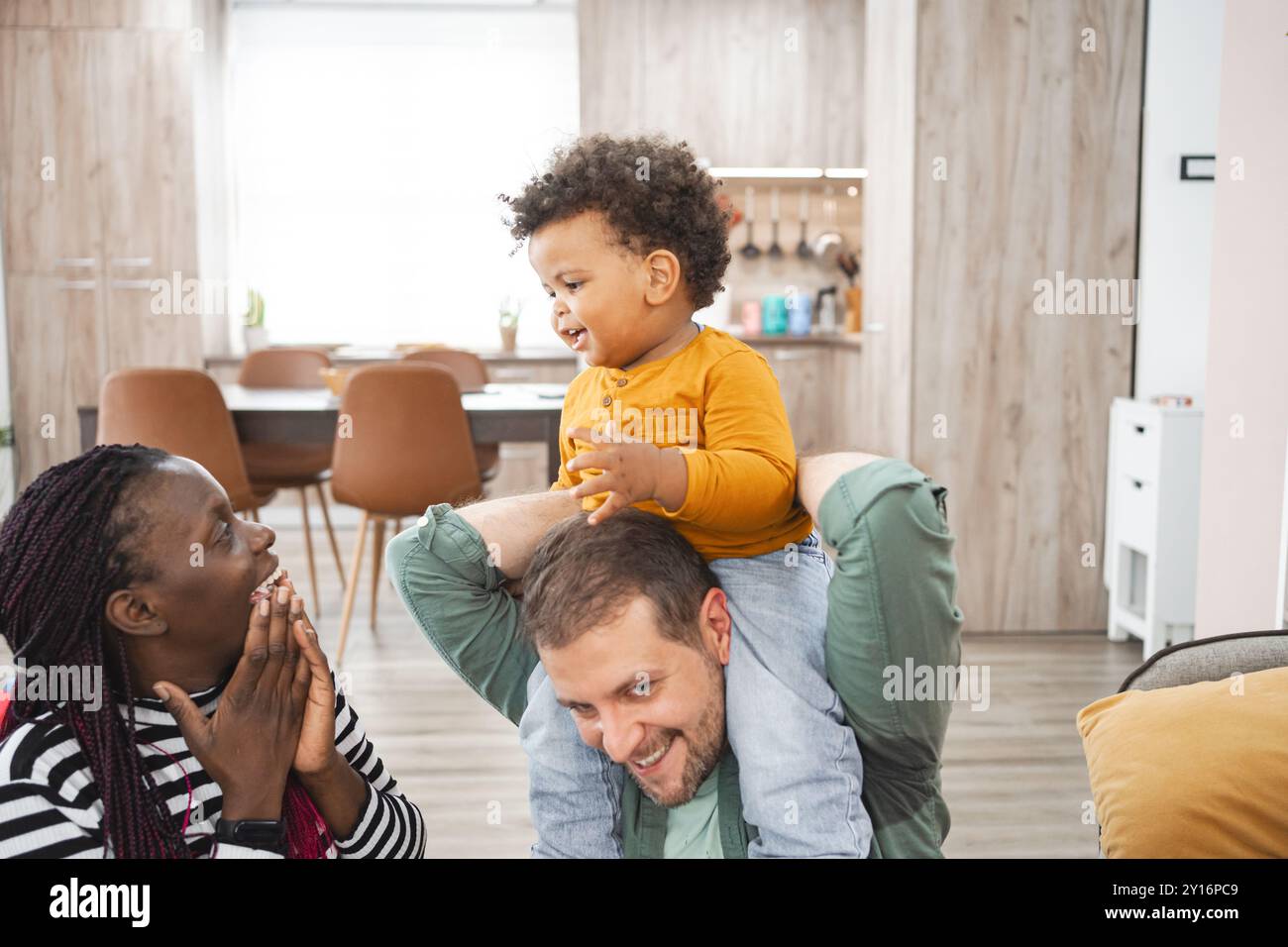 Famille multiraciale profitant de moments ludiques à l'intérieur dans la maison Banque D'Images