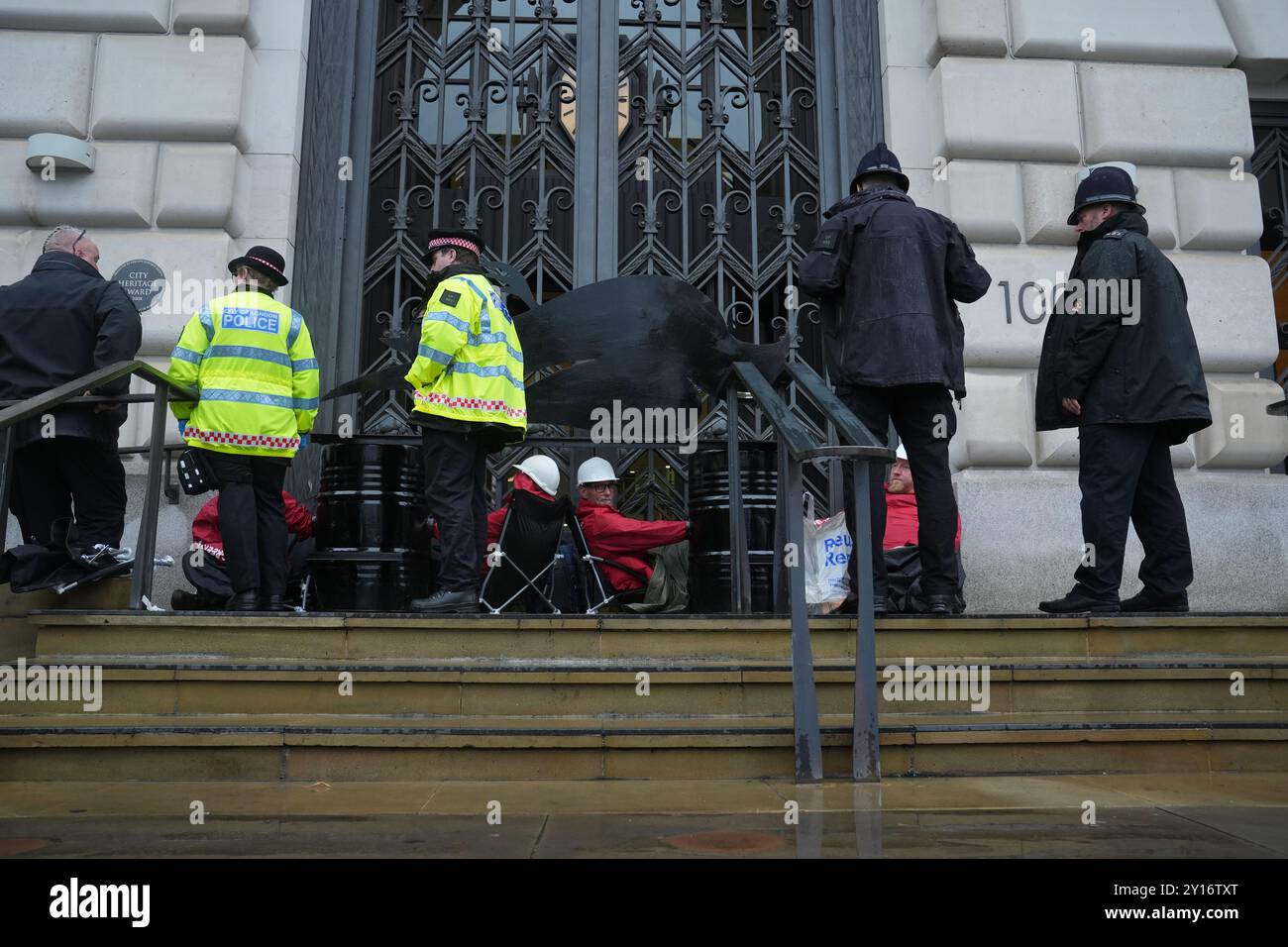 La police retire les militants devant le siège d'Unilever dans le centre de Londres, Greenpeace UK ayant bloqué l'accès au bâtiment, affirmant que la société de biens de consommation « saccage la planète et nuit aux communautés » à travers des plastiques à usage unique. Les membres du groupe de campagne pour l'environnement se sont bloqués sur des barricades fabriquées à partir de produits géants Dove, l'une des plus grandes marques d'Unilever, le logo de chaque produit étant changé en Dove morte. Date de la photo : jeudi 5 septembre 2024. Banque D'Images