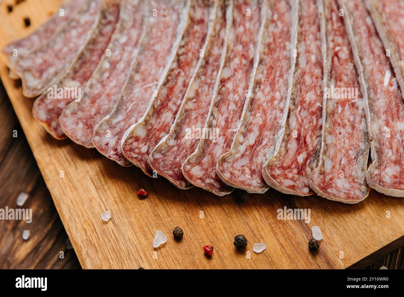 Gros plan de salami séché en tranches à bord, idéal pour les présentations gastronomiques et de charcuterie Banque D'Images