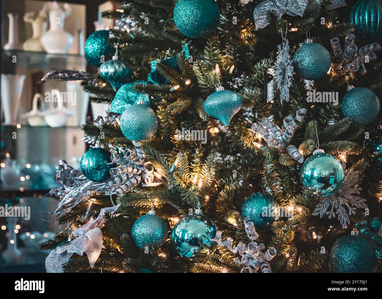 Gros plan d'ornements suspendus sur un arbre de Noël bien décoré dans un cadre confortable à la maison Banque D'Images