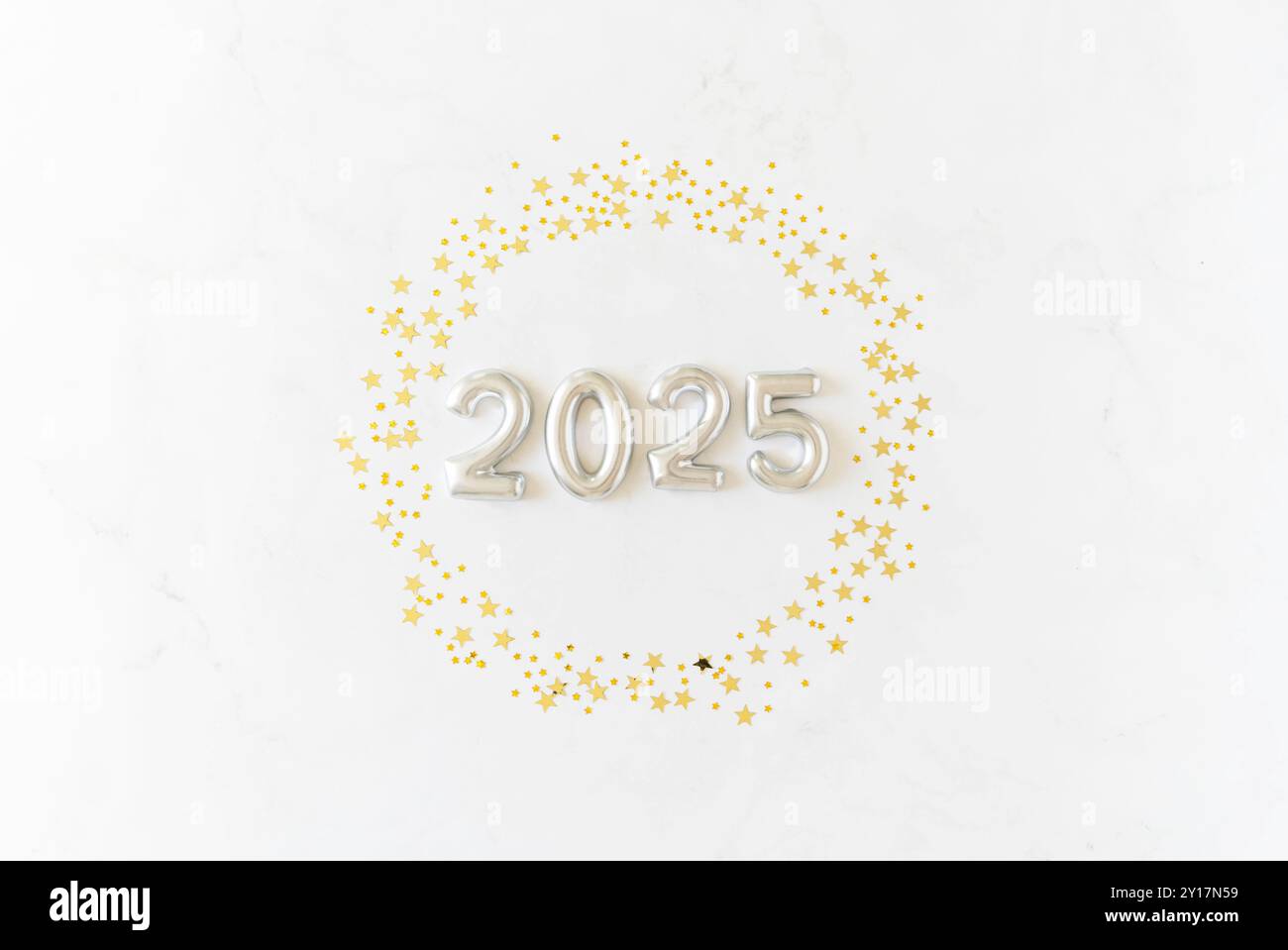 Carte de voeux - bonne année avec les numéros 2025 en étoiles pailletées dorées rondes sur fond blanc. Concept de vacances minimal. Vue de dessus. Pose à plat Banque D'Images