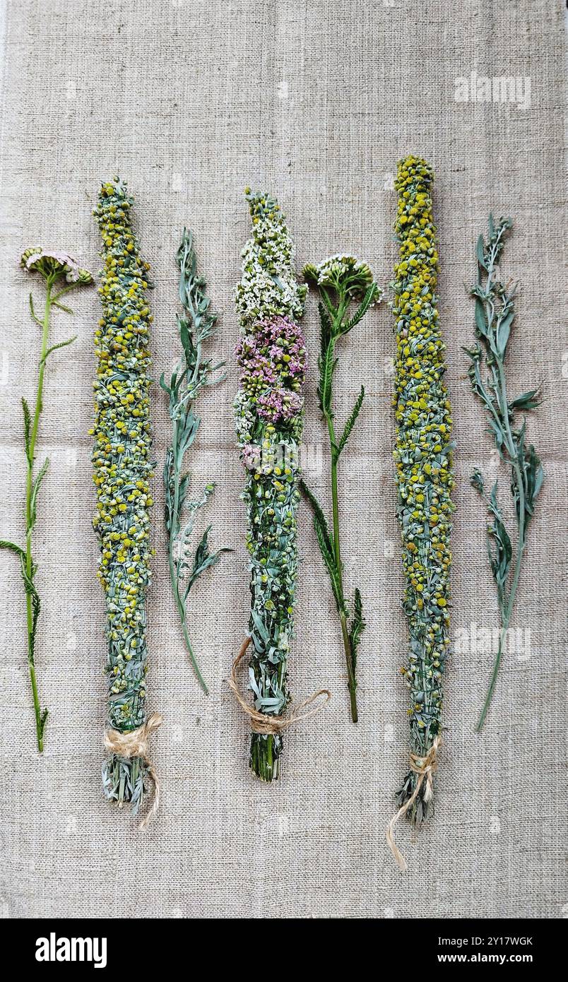 Bâtonnets assortis de taches à base de plantes avec des fleurs jaunes sur fond de lin Banque D'Images