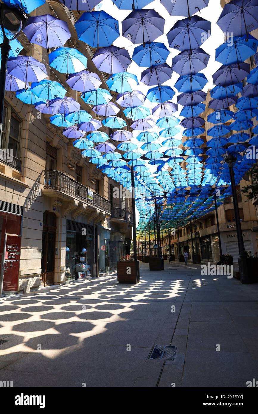 Albacete, Castilla la Mancha, Espagne- 23 août 2024 : parapluies colorés sous le ciel bleu sur la rue Calle Ancha dans la ville d'Albacete, Madrid, Espagne Banque D'Images