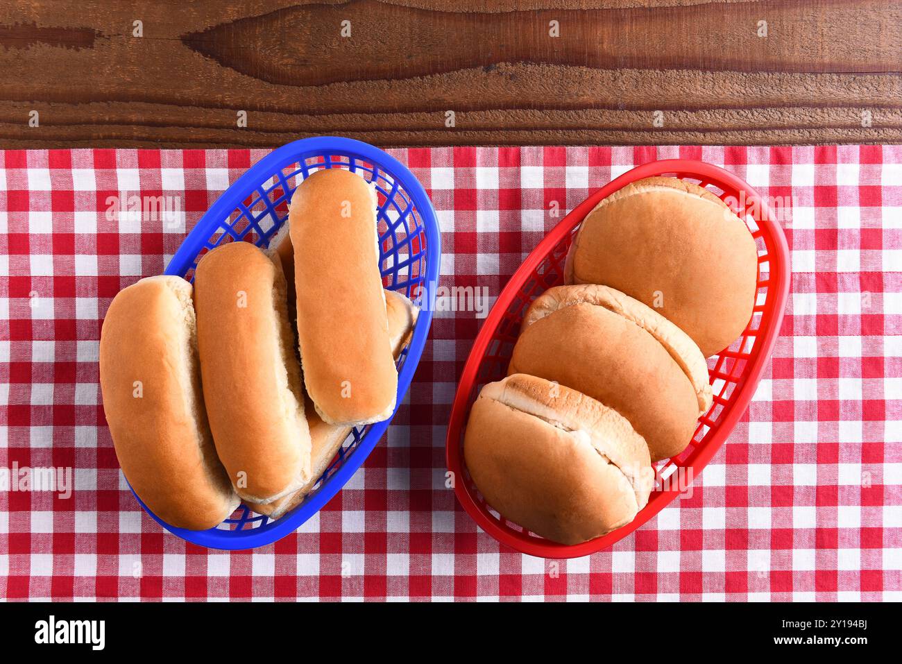 Pains hamburger et hot dog dans des paniers en plastique sur une table de pique-nique. l'image à thème rouge blanc et bleu convient aux thèmes patriotiques de vacances. Banque D'Images