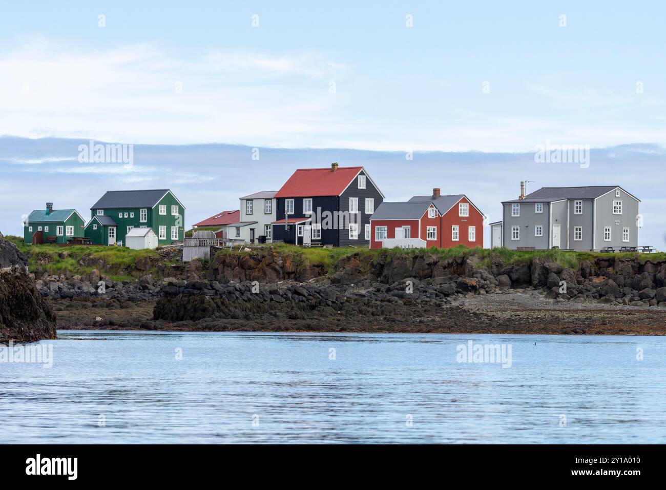 Des maisons colorées peintes à marée basse sur l'île islandaise Flatey contre le ciel bleu et les nuages. Flatey, Breiðafjörður, Westfjords, Islande Banque D'Images