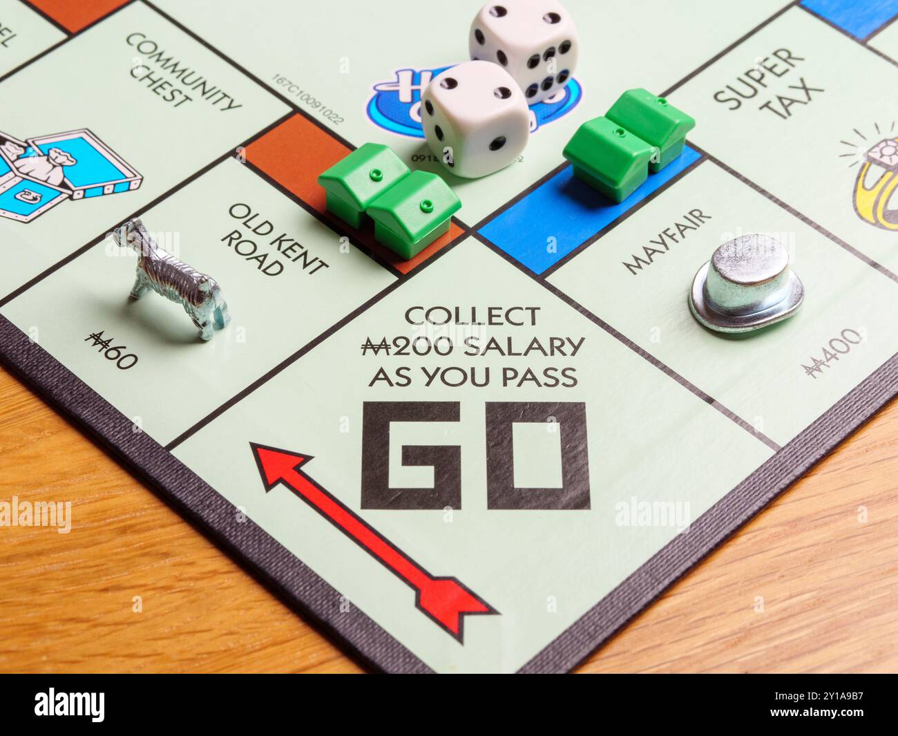 Gros plan de pièces de jeu qui passent à la place et reçoivent un salaire sur un jeu de société du Monopoly britannique de Londres Banque D'Images