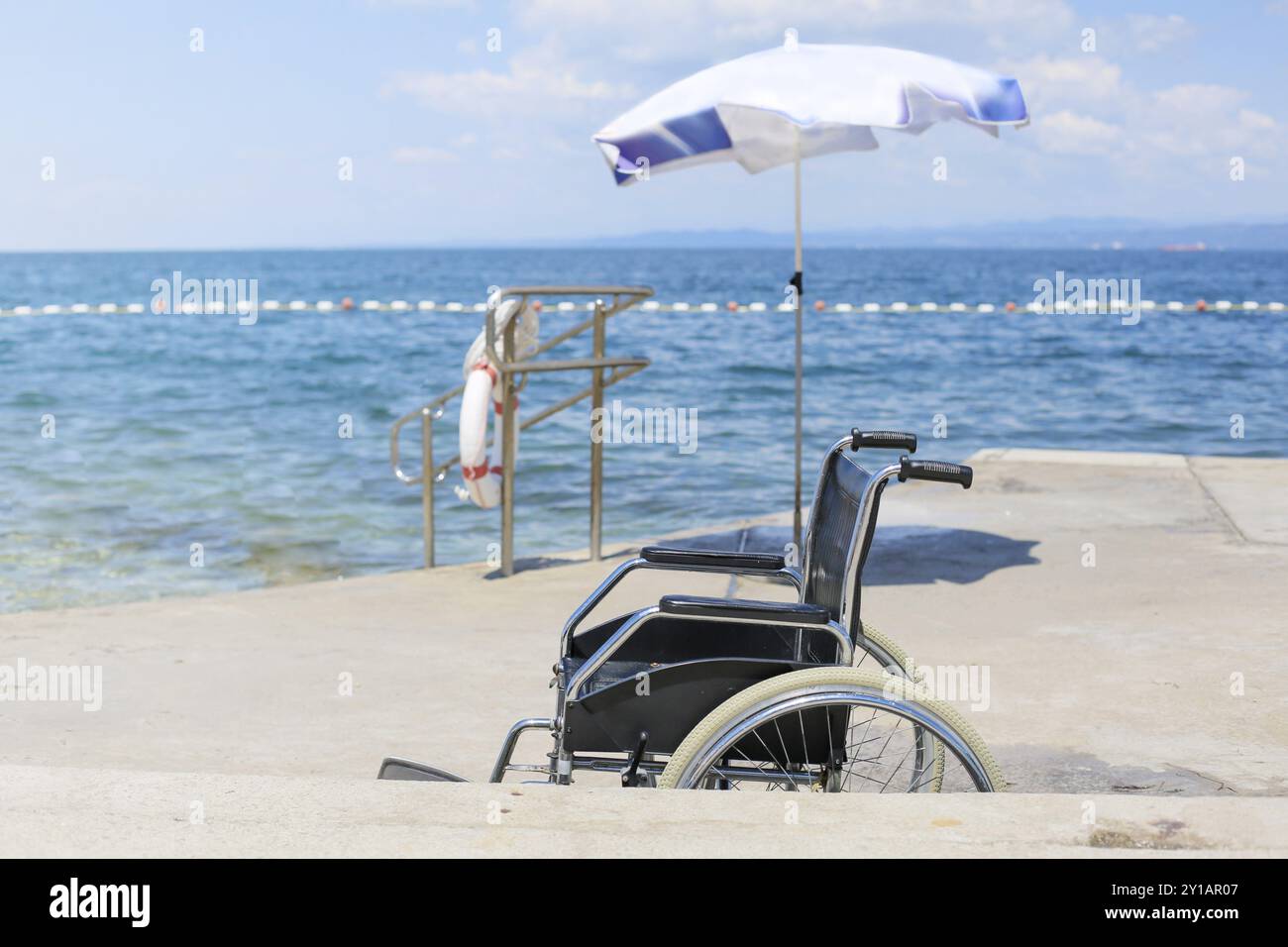 Fauteuil roulant sur une plage accessible pour le transport des personnes handicapées dans l'eau Banque D'Images