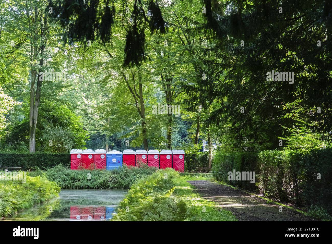 Une rangée de blocs sanitaires rouges et bleus dans le parc après un événement, Duesseldorf, Allemagne, Europe Banque D'Images