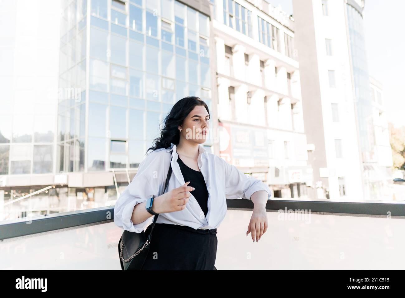 Femme d'affaires confiante dans le paysage urbain avec l'architecture moderne. Banque D'Images