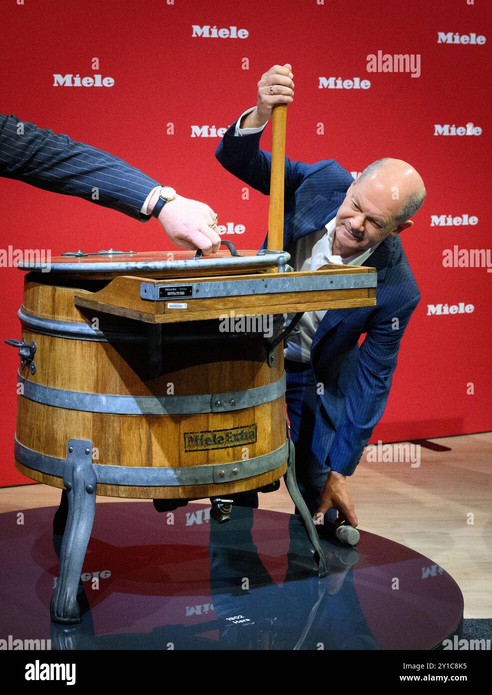 Berlin, Allemagne. 06 septembre 2024. Le chancelier fédéral Olaf Scholz (SPD) visite le stand Miele lors de sa tournée d'ouverture le premier jour public de la Foire internationale de l'électronique grand public IFA 2024 au centre des expositions de Berlin et examine la première machine à laver historique du fabricant d'appareils électroménagers. Environ 1 800 exposants et plus de 180 000 visiteurs sont attendus au 100e anniversaire du salon leader de l’électronique grand public et de l’électroménager du 6 au 10 septembre 2024. Crédit : Bernd von Jutrczenka/dpa/Alamy Live News Banque D'Images