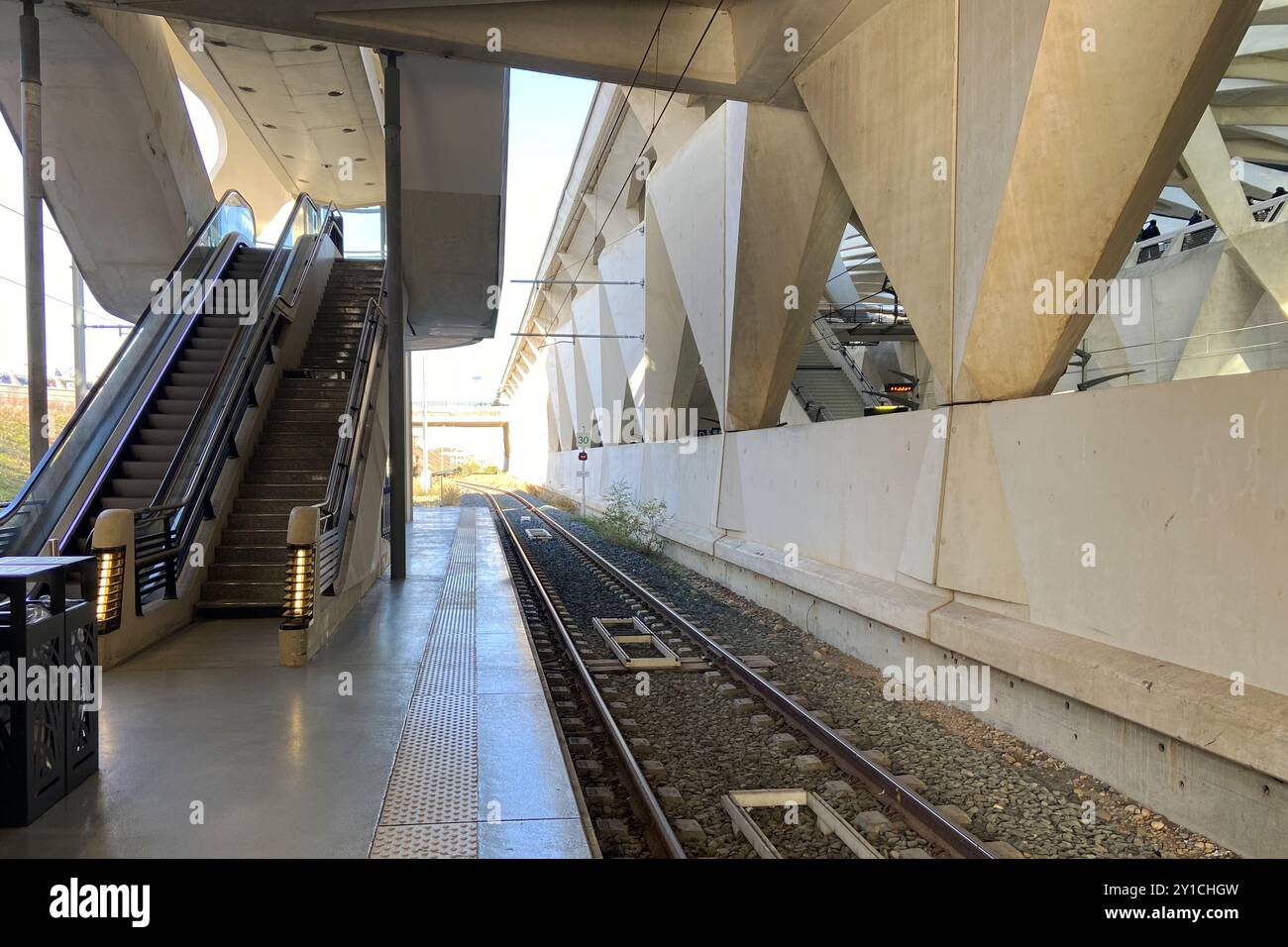 Vue en perspective des quais de train déserts vides et des rails d'une grande station de métro de banlieue urbaine à Lyon, France Banque D'Images