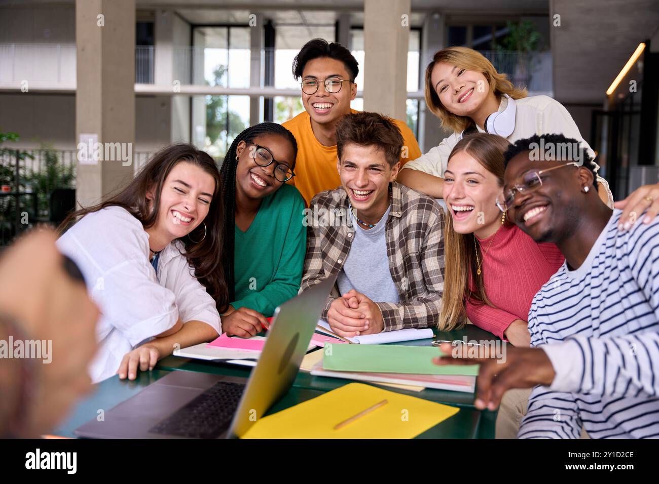 Groupe de jeunes étudiants divers gens posant joyeux pour la photo dans la cafétéria sur le campus universitaire. Banque D'Images