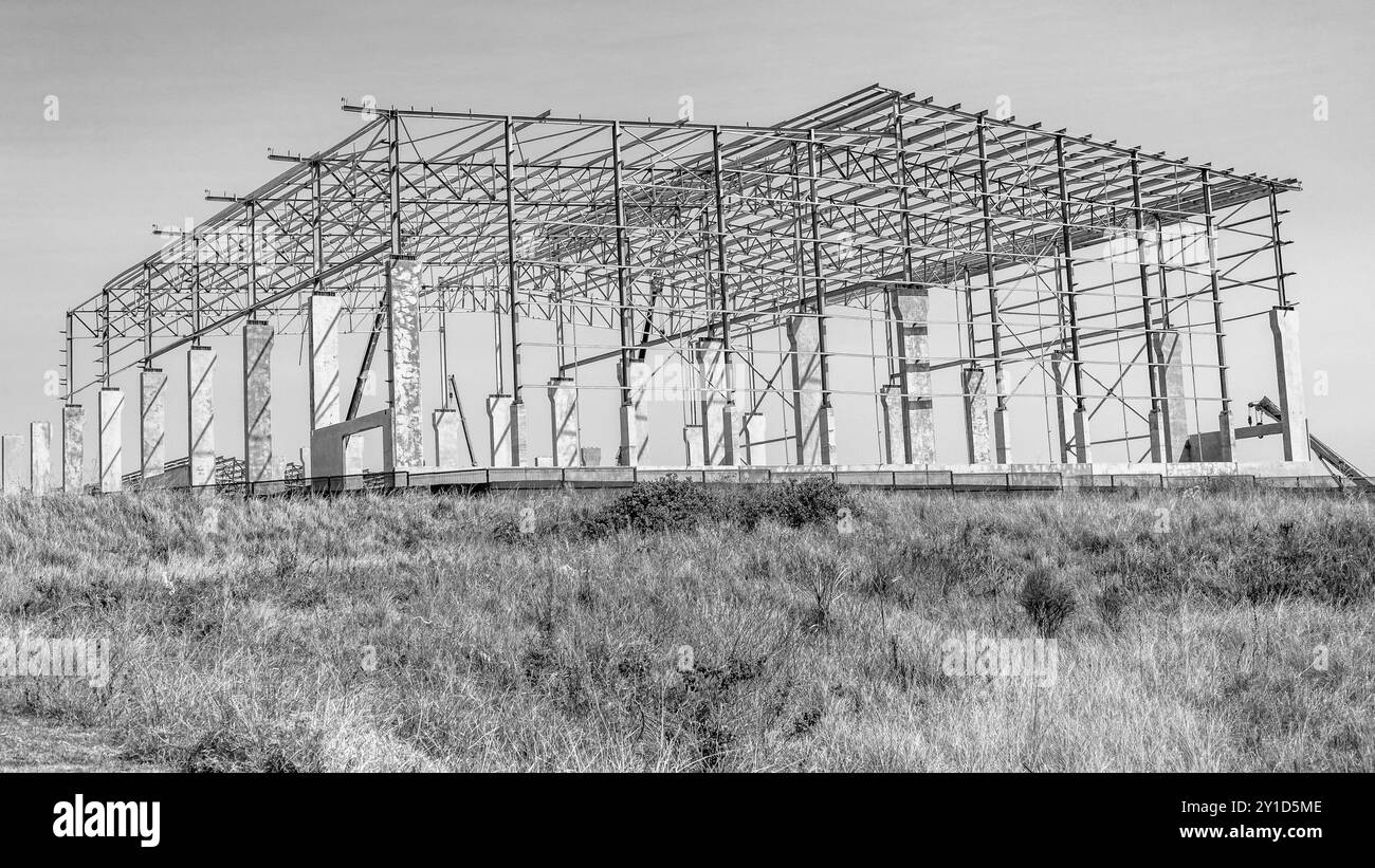 Structure d'entrepôt de bâtiment en acier poutres à mi-chemin dans la construction en silhouette noir et blanc photographie Banque D'Images