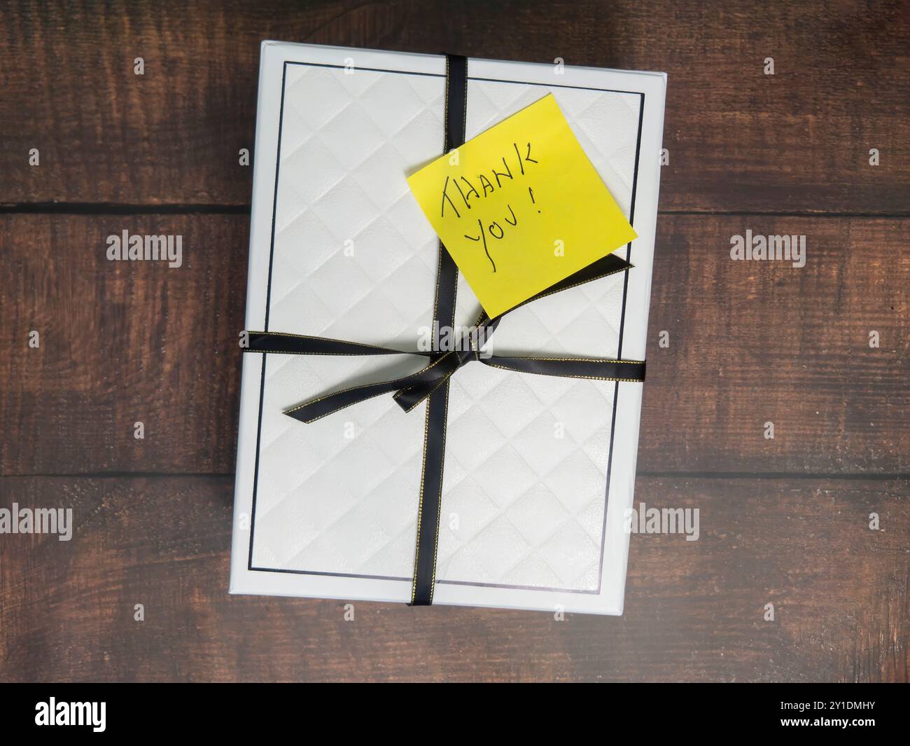 Jaune Merci Post-it Note sur la boîte cadeau avec ruban noir sur un fond de bois Banque D'Images