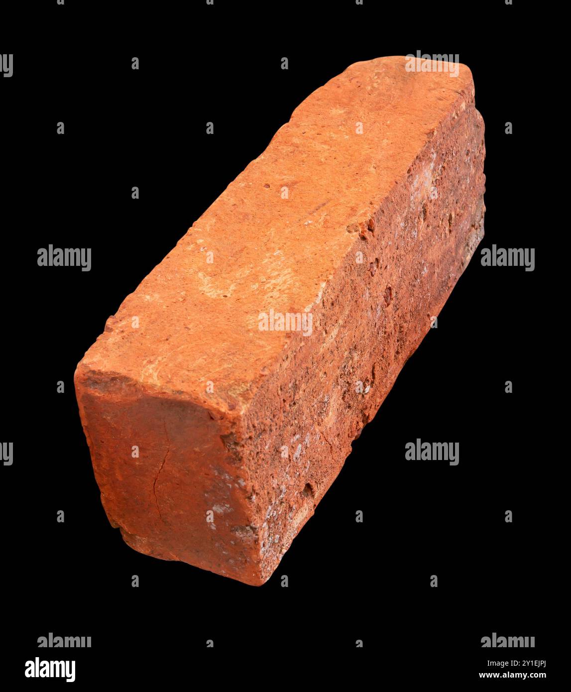 La vue latérale de la vieille brique rouge ou orange est isolée sur fond noir. Banque D'Images