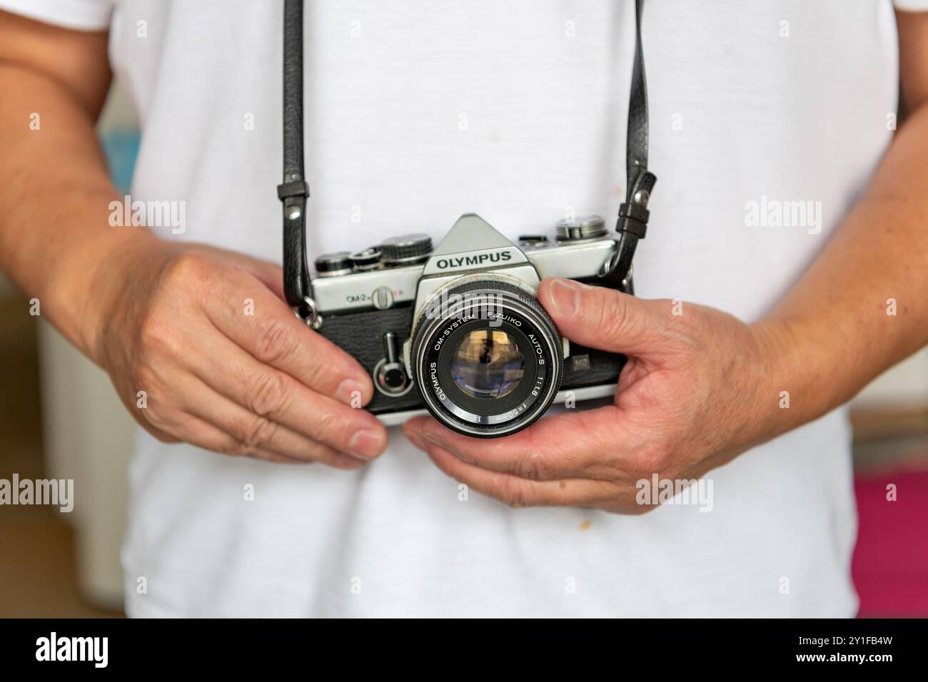 Londres. UK- 09.03.2024. Une personne portant un appareil photo Olympus vintage, un reflex utilisant des rouleaux de négatifs de film. Banque D'Images