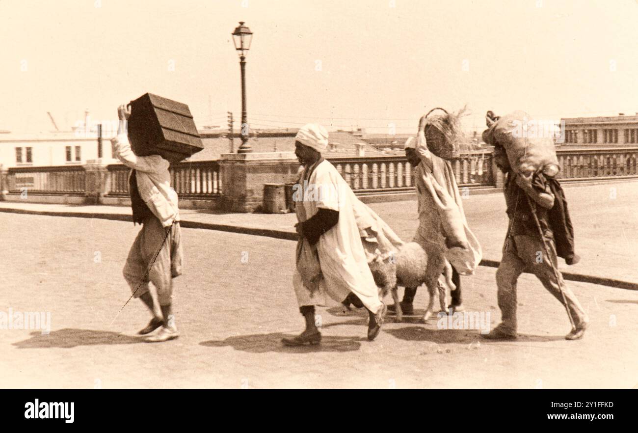 Photo tirée de l'album du voyage de l'Italie à l'Algérie et à Londres de la famille juive milanaise au milieu des années trente. En particulier, la photo montre un groupe d'hommes se rendant à un marché local pendant l'occupation coloniale française Banque D'Images