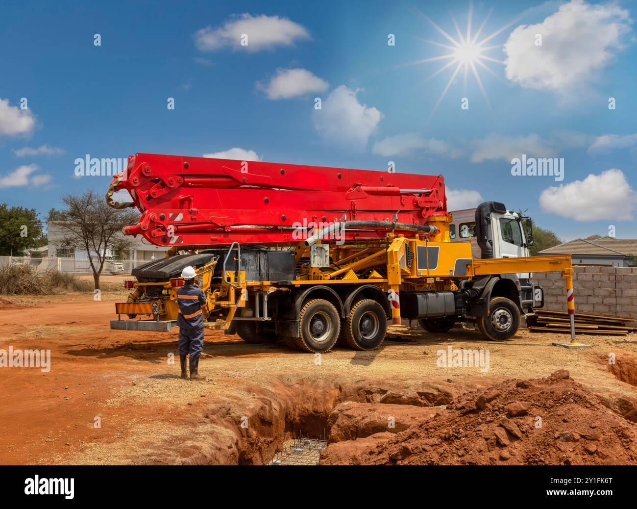 grue de pompe à béton, camion de services de pompage de béton versant du béton liquide, travailleur de la construction africain Banque D'Images