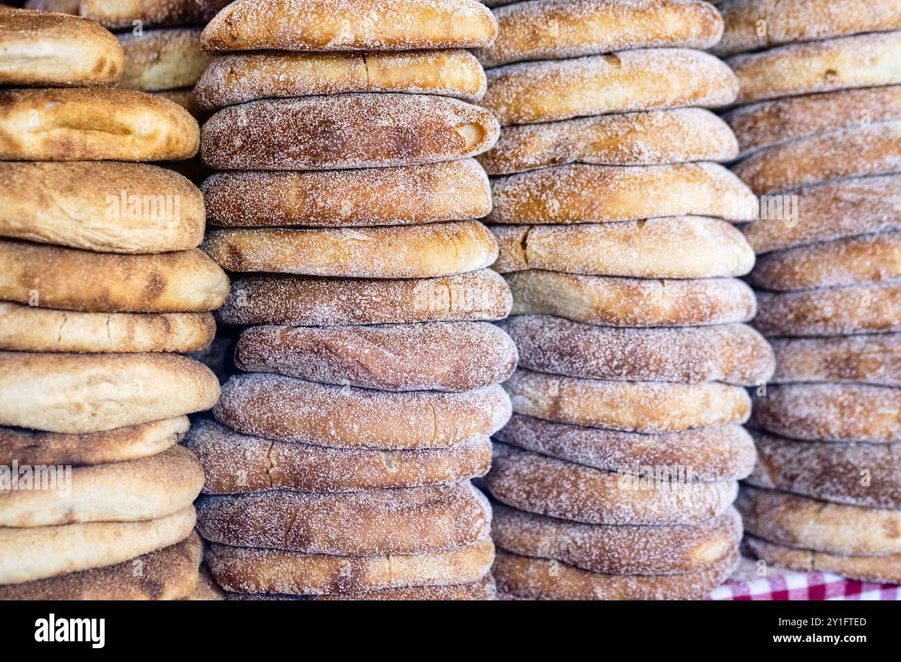 Pile de pain marocain frais à l'étal du marché de rue. Pain traditionnel fraîchement cuit appelé khubz, batbout, Mkhamer ou harcha au Maroc Banque D'Images