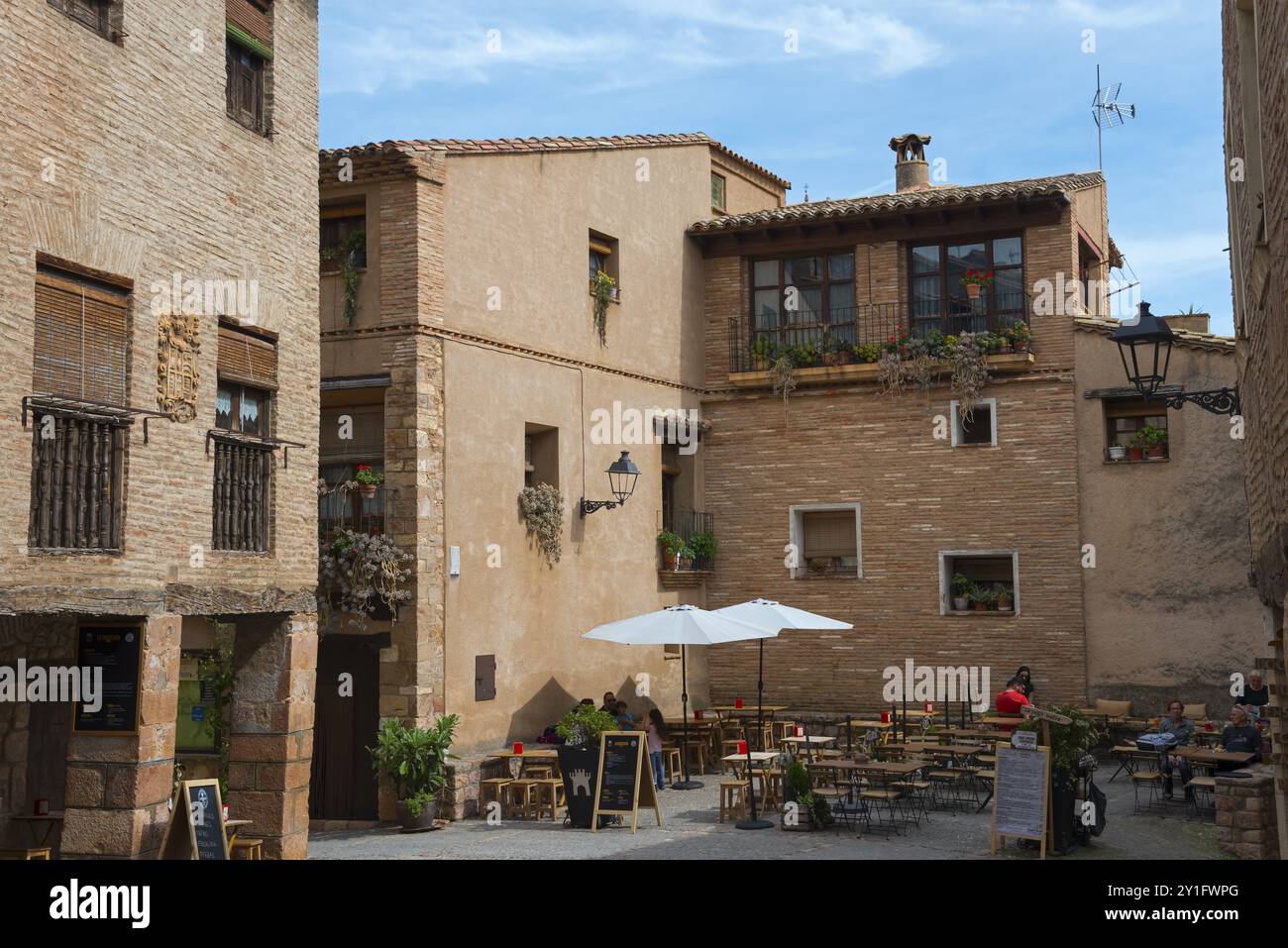 Un café de trottoir confortable parmi les bâtiments historiques dans un petit centre-ville ensoleillé, Rafael Ayerbe Square, Old Plaza Mayor, Alquezar, Alquezar, Huesca, Arag Banque D'Images