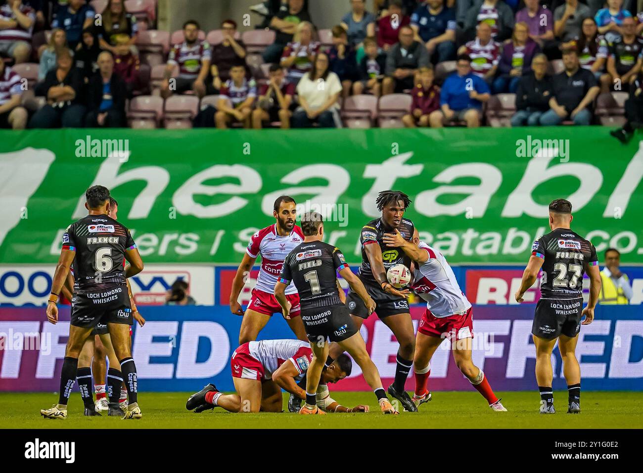 Wigan, Royaume-Uni. 6 septembre 2024. Super League Rugby : Wigan Warriors vs Hull KR au Brick Stadium. Junior Nsemba à la recherche du déchargement pendant le tacle, crédit James Giblin/Alamy Live News. Banque D'Images