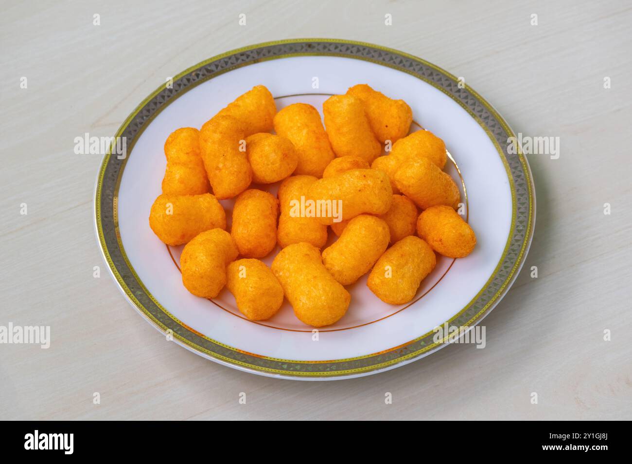 Casse-croûte au fromage craquelins chips sur une assiette blanche sur fond de bois clair. Banque D'Images