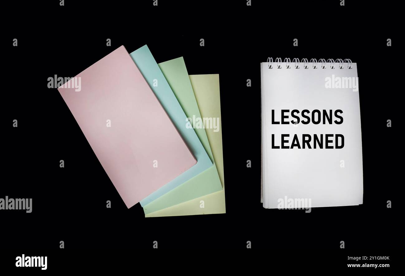 Bloc-notes avec texte leçons apprises sur un fond noir. Concept commercial. Banque D'Images