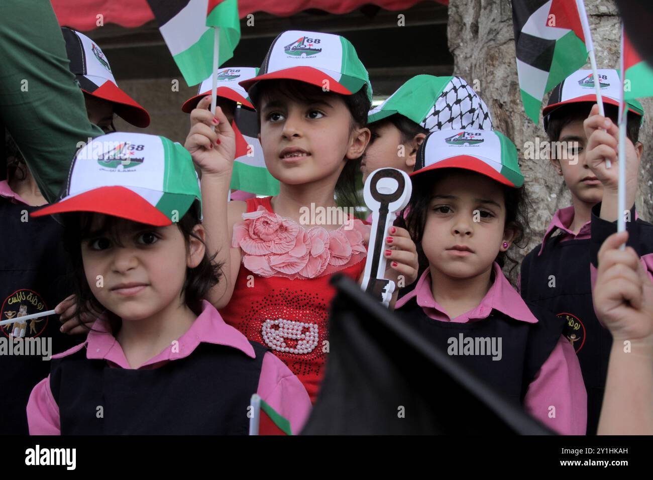 Un garçon palestinien tient une grande clé devant une affiche lors d'un rassemblement pour commémorer le 68e anniversaire de la Nakba Banque D'Images