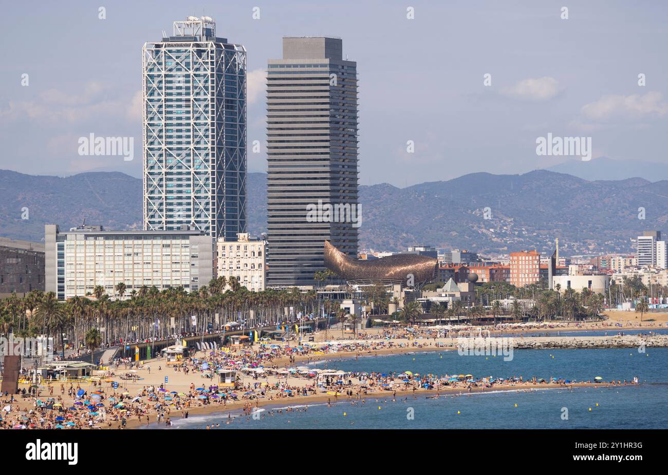 BARCELONE, ESPAGNE - 31 AOÛT 2024 : célèbres tours olympiques et personnages le long de la plage de Barceloneta dans le quartier Ciutat Vella de Barcelone, Espagne Banque D'Images