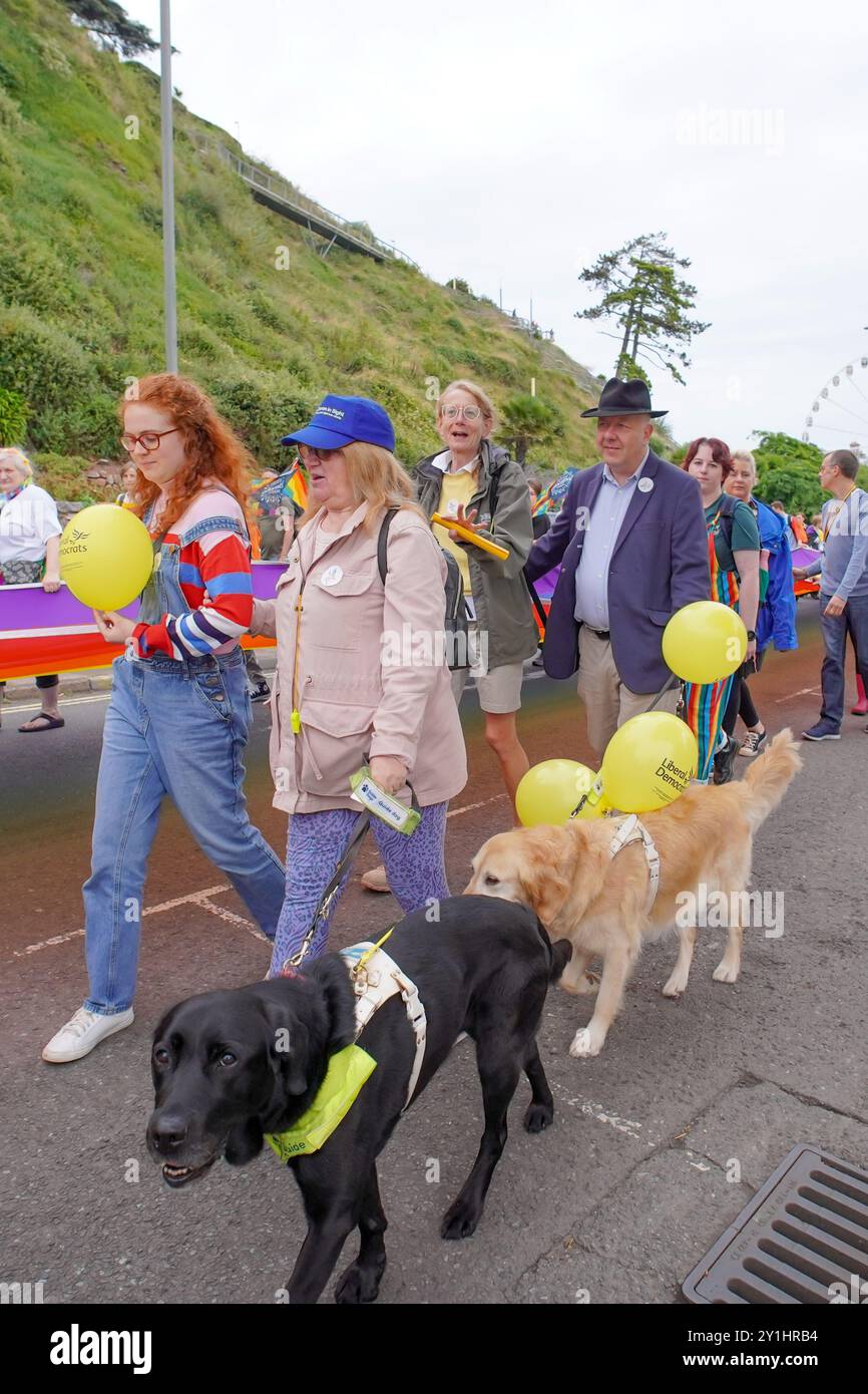 Torquay, Royaume-Uni. 7 septembre 2024. Le député Steve Darling, accompagné de son chien-guide Jennie, a aidé à porter le drapeau de la fierté dans le cadre de l'événement Torbay Pride à Torquay. La deuxième célébration annuelle LGBT dans la ville balnéaire. Crédit : Thomas Faull/Alamy Live News Banque D'Images