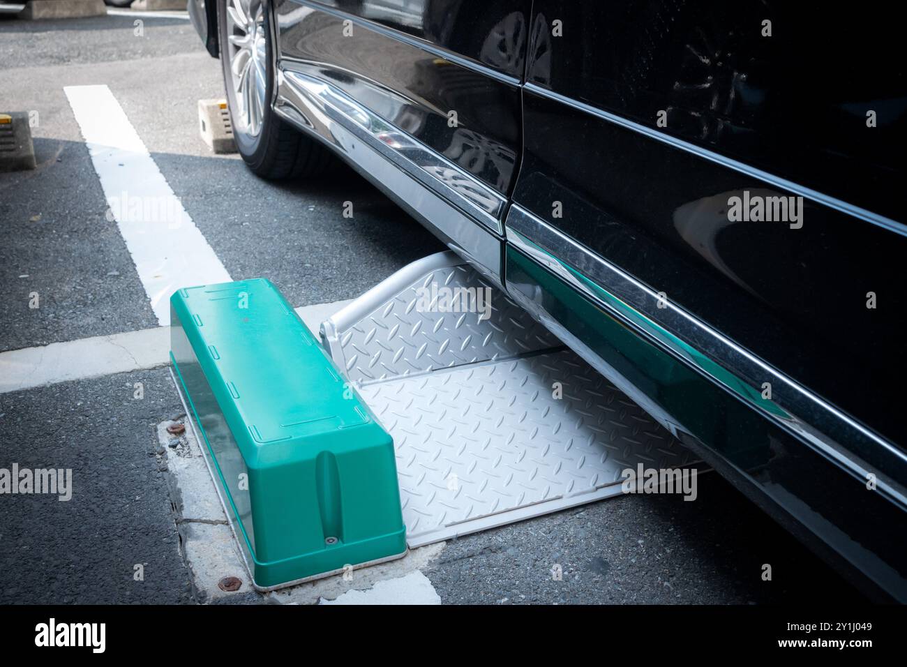 Serrure de roue en métal sous une voiture au stationnement payant de pièce au japon Banque D'Images