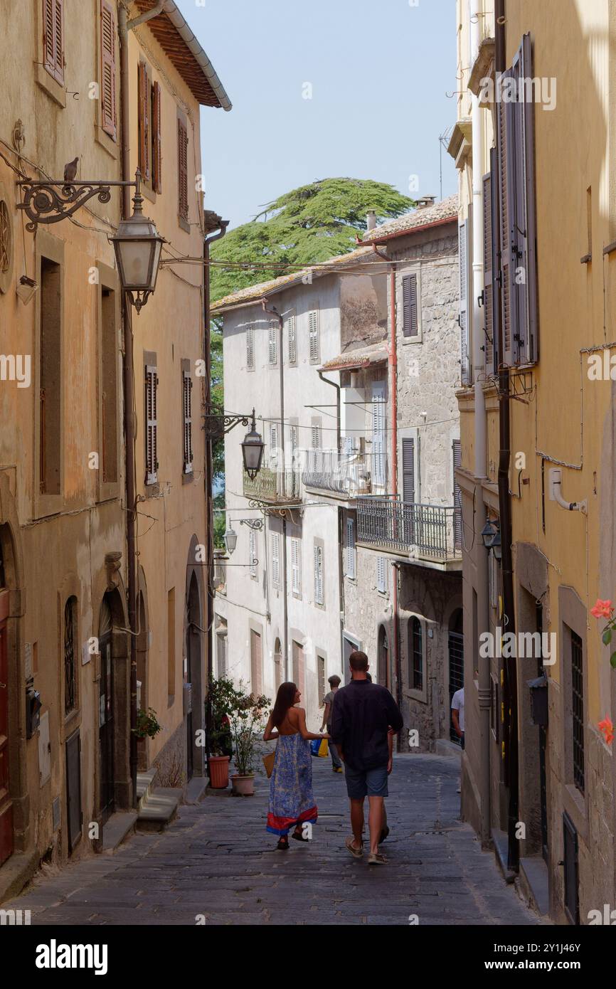 Couple marcher dans une rue étroite dans la ville de Montefiacone, région du Latium, Italie. 07 avril 2024 Banque D'Images