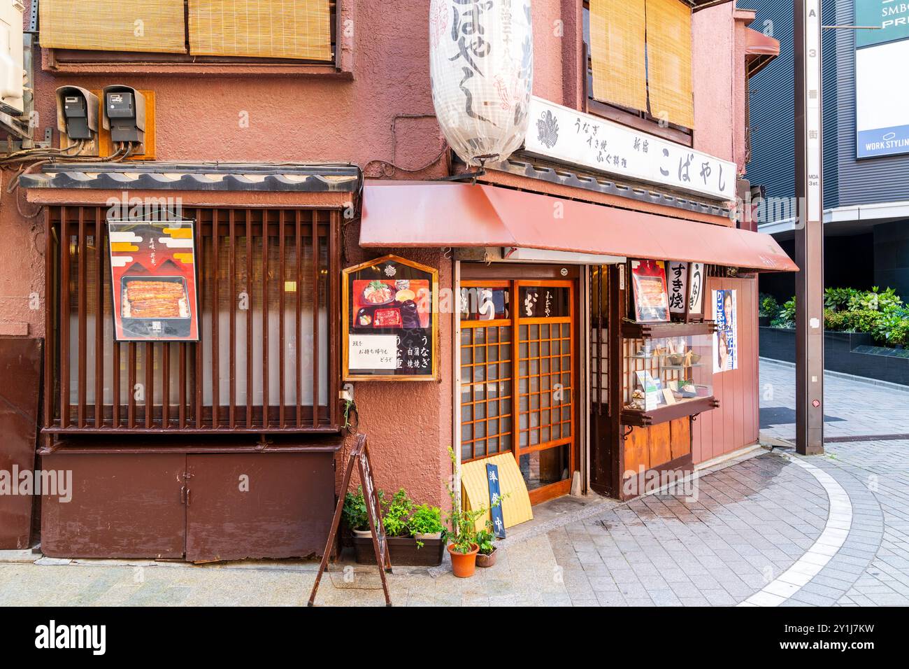 Restaurant japonais typique au coin de la rue dans le quartier Kabukichō de Shinjuku. Lanterne au-dessus de l'entrée et porte coulissante traditionnelle en bois. Banque D'Images