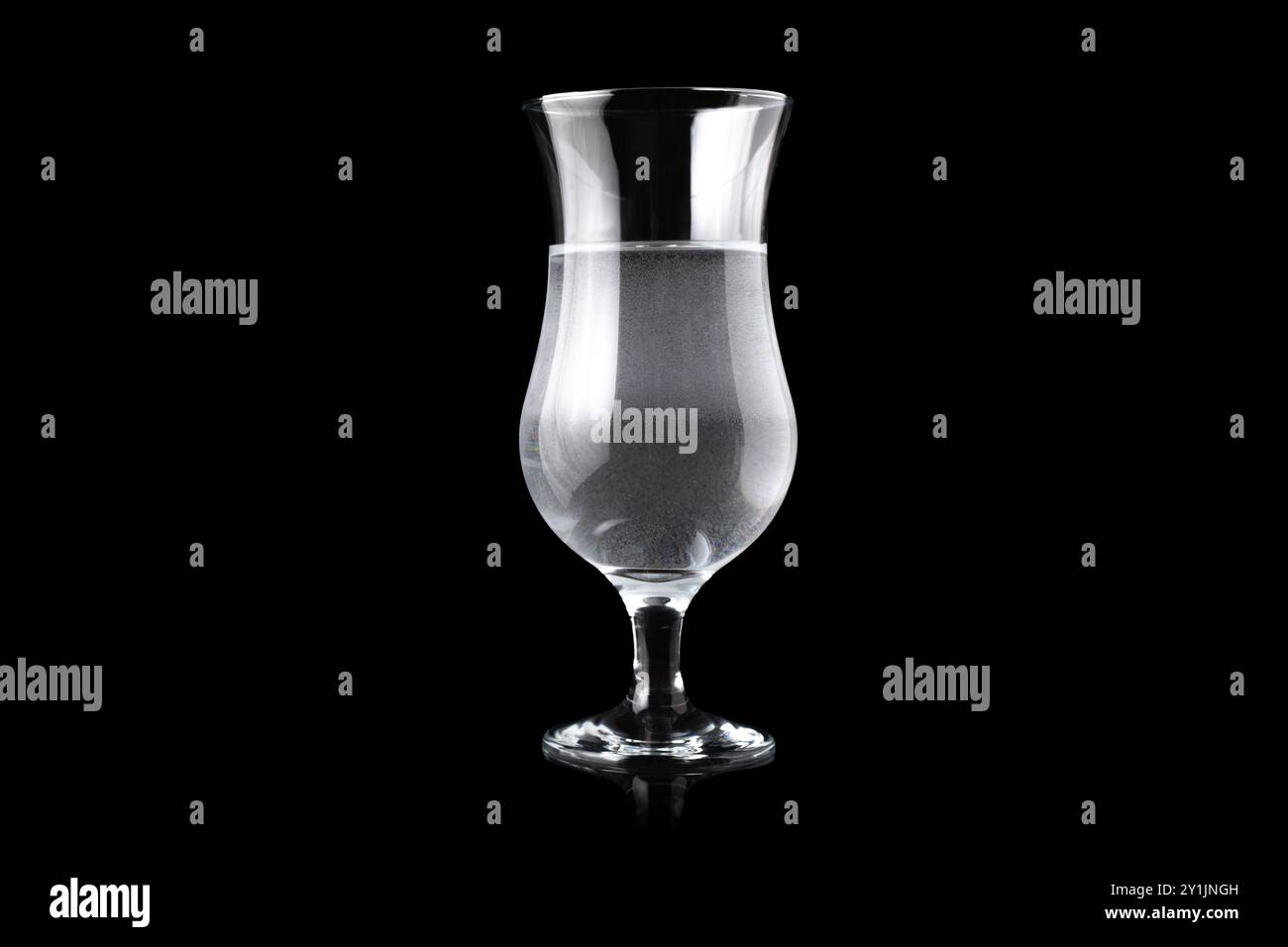 Verre ouragan rempli d'eau, debout au milieu. Espace vide pour le texte. Banque D'Images