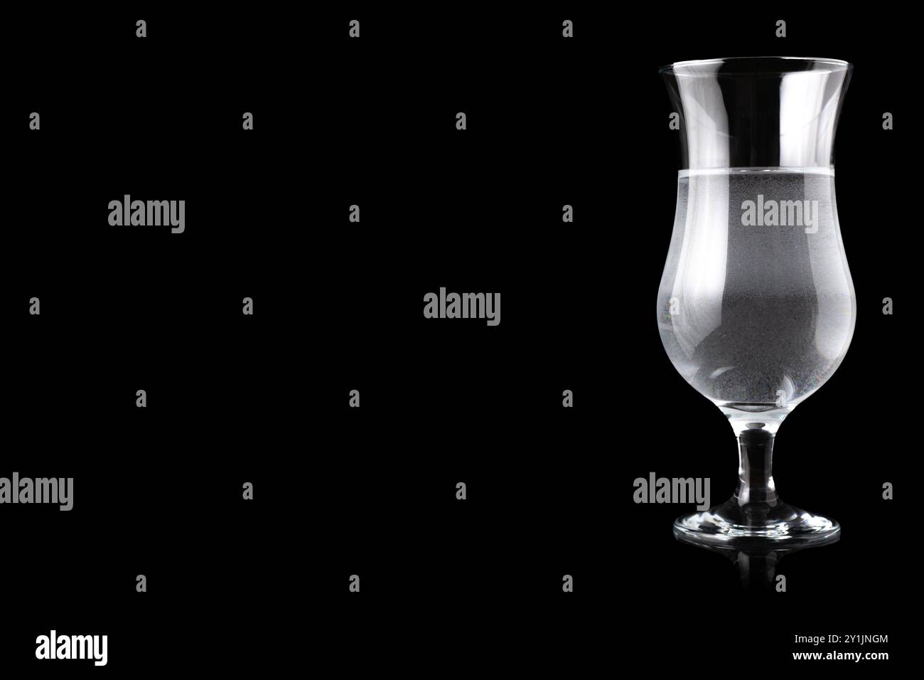 Verre Hurricane rempli d'eau, debout sur le côté droit. Espace vide pour le texte. Banque D'Images