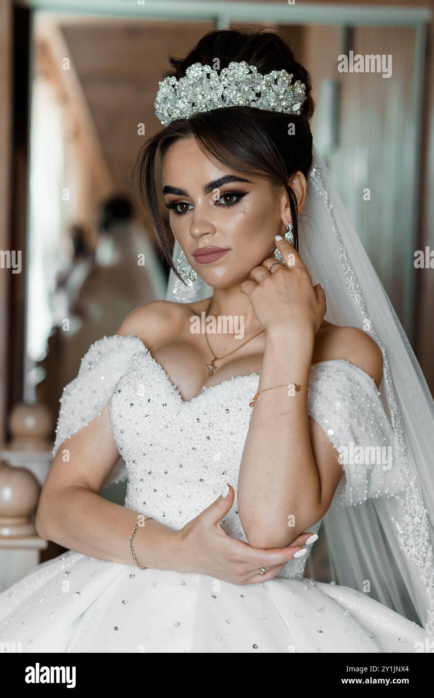 Élégante mariée en robe blanche étincelante avec Tiara en cristal ornée et magnifique maquillage Banque D'Images