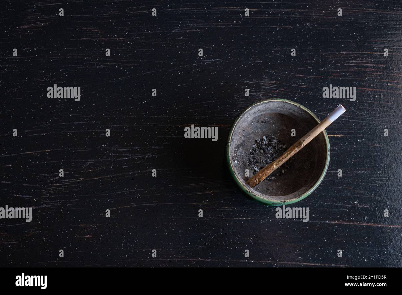 420. Légaliser, dépénaliser Europe, États-Unis, Canada. Cigarette commune de marijuana sur un cendrier sale avec motif de feuilles de cannabis, plat isolé sur Banque D'Images