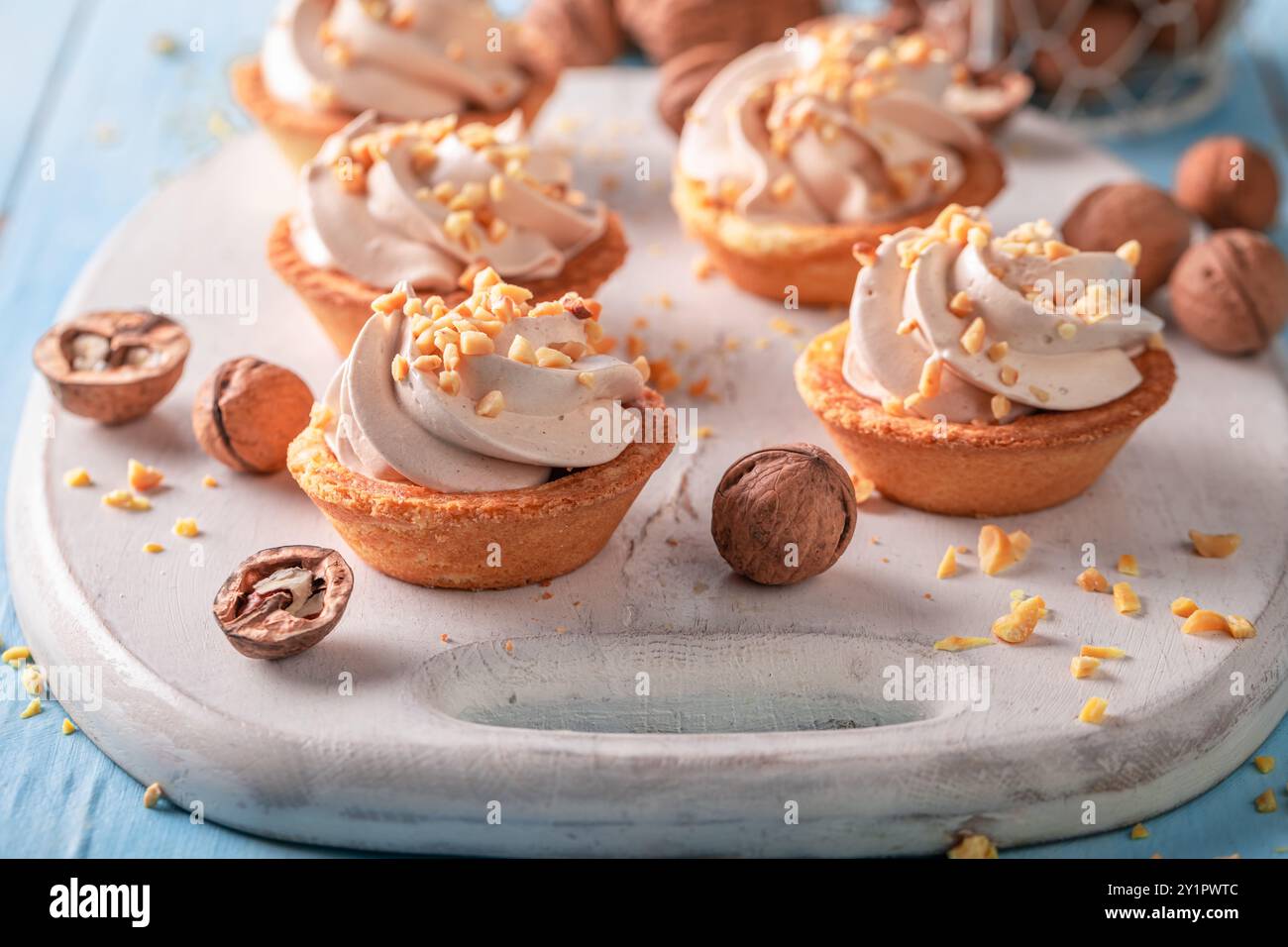 Mini tartelettes faites maison avec des noix et de la crème à la vanille. Dessert sucré simple avec des noix. Banque D'Images